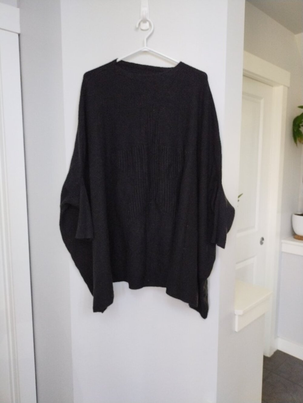 Black knit poncho with star design on the front